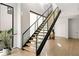 Modern staircase with wood treads, glass railings, and black accents provides a sleek and open design at 1051 Wimberly Ne Rd, Brookhaven, GA 30319