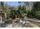 Backyard patio with a stone pathway, lush greenery, retaining wall and outdoor dining set, perfect for outdoor entertaining at 1605 E Sussex Ne Rd, Atlanta, GA 30306