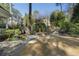 Backyard featuring stone patio, fire pit, stone retaining walls with lush plantings, and a well-manicured lawn at 1605 E Sussex Ne Rd, Atlanta, GA 30306