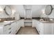 Symmetrical bath featuring dual sinks and vanities with a central vanity and white cabinets under a shuttered window at 1605 E Sussex Ne Rd, Atlanta, GA 30306