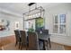 Modern dining room featuring a black table, striped chairs, unique chandelier, and a view of a shuttered window at 1605 E Sussex Ne Rd, Atlanta, GA 30306