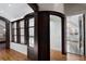 Hallway featuring hardwood floors, dark trim windows, and views into bedroom and ensuite bath at 1605 E Sussex Ne Rd, Atlanta, GA 30306