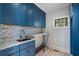 Well-equipped laundry room features blue cabinets and a granite countertop folding station at 1605 E Sussex Ne Rd, Atlanta, GA 30306