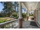 Covered porch overlooking backyard with stone flooring, white railings, and views of mature trees and lawn furniture at 1605 E Sussex Ne Rd, Atlanta, GA 30306