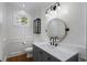 Modern powder room features a stylish vanity with a round mirror and elegant light fixture at 1605 E Sussex Ne Rd, Atlanta, GA 30306