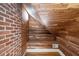 Unique staircase with cedar plank walls ascends past an exposed brick wall creating a rustic and distinctive architectural detail at 1605 E Sussex Ne Rd, Atlanta, GA 30306