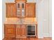 Entertainment area with wood cabinets, granite countertops, tile backsplash and beverage cooler at 1965 Carlotta Ct, Atlanta, GA 30345