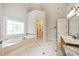 Elegant bathroom featuring a soaking tub with a decorative window and glass-enclosed shower at 1965 Carlotta Ct, Atlanta, GA 30345