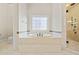 Bright bathroom features tub with decorative window and glass enclosed shower at 1965 Carlotta Ct, Atlanta, GA 30345