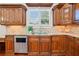 Bright kitchen featuring wood cabinets, granite countertops, stainless dishwasher, and stylish tile backsplash at 1965 Carlotta Ct, Atlanta, GA 30345