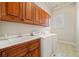 Functional laundry room featuring wooden cabinets, white countertops, a sink, and modern washer and dryer at 1965 Carlotta Ct, Atlanta, GA 30345