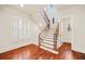 Bright foyer showcases a staircase with hardwood steps, decorative wrought iron spindles, and gleaming hardwood floors at 1965 Carlotta Ct, Atlanta, GA 30345