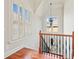 Second floor landing featuring wood floors and stair case with decorative wrought iron spindles and a view to the outdoors at 1965 Carlotta Ct, Atlanta, GA 30345