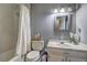 This bathroom features honeycomb tiles in the shower, a classic vanity, and ample lighting for a bright and functional space at 3085 Nappa Trl, Stone Mountain, GA 30087