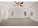 Large main bedroom featuring a ceiling fan, tray ceiling, and natural light from multiple windows at 5436 Flat Rock Point Pt, Stonecrest, GA 30038