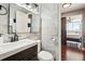 Modern bathroom boasts marble tile, a dark wood vanity, and a view of the bedroom at 215 Piedmont Ne Ave # 1804, Atlanta, GA 30308