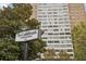 Exterior view of The Landmark Condominiums sign and building behind mature trees at 215 Piedmont Ne Ave # 1804, Atlanta, GA 30308