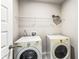 Bright laundry room with white washer and dryer, and metal shelving at 3596 Maple Hill Rd, Lithonia, GA 30038