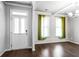 Inviting living room featuring hardwood floors, white trim, and abundant natural light from two windows at 3596 Maple Hill Rd, Lithonia, GA 30038