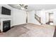 A bright living room featuring a fireplace, ceiling fan, and staircase leading to the upper level at 3596 Maple Hill Rd, Lithonia, GA 30038