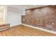 Finished basement with red brick wall, wood flooring, and unique brick arch detail at 869 Briarcliff Ne Rd # B25, Atlanta, GA 30306