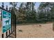 Community dog park area with gravel ground, greenery, and pet waste control signage at 869 Briarcliff Ne Rd # B25, Atlanta, GA 30306