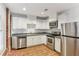 Well-lit kitchen with stainless steel appliances, white cabinetry, and wood flooring at 869 Briarcliff Ne Rd # B25, Atlanta, GA 30306