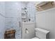 Bright, white shower featuring marble tiles, glass door, overhead shower and a wooden bench at 949 Park Se Ave, Atlanta, GA 30315