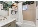 Charming bathroom with floral wallpaper, tiled tub, and a vanity with a brass faucet at 949 Park Se Ave, Atlanta, GA 30315