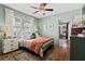 Cozy bedroom featuring stylish decor, ceiling fan and plush bedding, complemented by ample natural light from the windows at 949 Park Se Ave, Atlanta, GA 30315