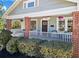 Inviting front porch with red brick pillars, white railing and beautiful hanging flower baskets at 949 Park Se Ave, Atlanta, GA 30315