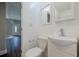 Bright half-bathroom featuring modern sink, white fixtures and flooring, and a wall mirror at 200 Adeline Nw Ave, Atlanta, GA 30314