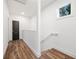 Upstairs hallway featuring new vinyl flooring, a window, a half-wall partition and a black door at 2664 Brown Nw St, Atlanta, GA 30318