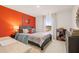 Bedroom with orange walls, a large dark-wood dresser, and a view out the window at 5441 Flat Rock Point Pt, Stonecrest, GA 30038