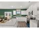 Bright kitchen features white cabinetry, granite countertops, stainless steel appliances, and an island at 5441 Flat Rock Point Pt, Stonecrest, GA 30038