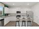 Bright kitchen with white cabinets, granite counters, stainless appliances, and bar stool seating at 5441 Flat Rock Point Pt, Stonecrest, GA 30038