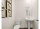Clean and modern powder room featuring a pedestal sink, toilet, and stylish artwork on the wall at 5441 Flat Rock Point Pt, Stonecrest, GA 30038