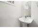 Clean, modern powder room featuring a pedestal sink, faucet, and a framed mirror with natural light at 2680 Brown Nw St, Atlanta, GA 30318