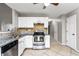 Functional kitchen featuring white cabinets, granite countertops, tile backsplash, and stainless steel dishwasher at 2738 Lakewater Way, Snellville, GA 30039