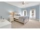 Light-filled bedroom with light blue walls, carpeted floors, and a ceiling fan at 2930 Monticello Dr, Cumming, GA 30041