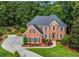 An elevated view of a brick house boasting manicured lawns and a long driveway at 2930 Monticello Dr, Cumming, GA 30041