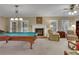 Carpeted living room with a fireplace, windows, and a pool table at 2930 Monticello Dr, Cumming, GA 30041