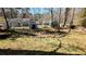 A grassy backyard with a shed and mature trees under a clear blue sky at 4195 Bradley Dr, Snellville, GA 30039