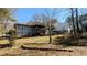 Backyard of home featuring a small deck with stairs surrounded by mature trees and lawn at 4195 Bradley Dr, Snellville, GA 30039