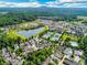 Panoramic aerial view of a residential community with a lake, tennis courts, and lush greenery at 5705 Odell St, Cumming, GA 30040