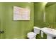 Stylish green powder room featuring a pedestal sink and unique decor at 5705 Odell St, Cumming, GA 30040