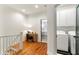 Hallway with stairs, leading to laundry area and a view of a bedroom at 5705 Odell St, Cumming, GA 30040