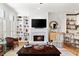 Inviting living room featuring a fireplace, built-in shelving, and hardwood floors at 5705 Odell St, Cumming, GA 30040