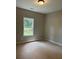Neutral bedroom features a window, ceiling light, and a closet at 8141 Hickory Dr, Covington, GA 30014