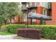 Exterior view showcasing the building's brick facade and covered entryway, surrounded by lush landscaping at 2840 Peachtree Nw Rd # 301, Atlanta, GA 30305